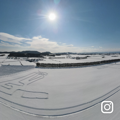 インスタグラム投稿イメージ 冬の晴天に輝く太陽と足跡の残る平原